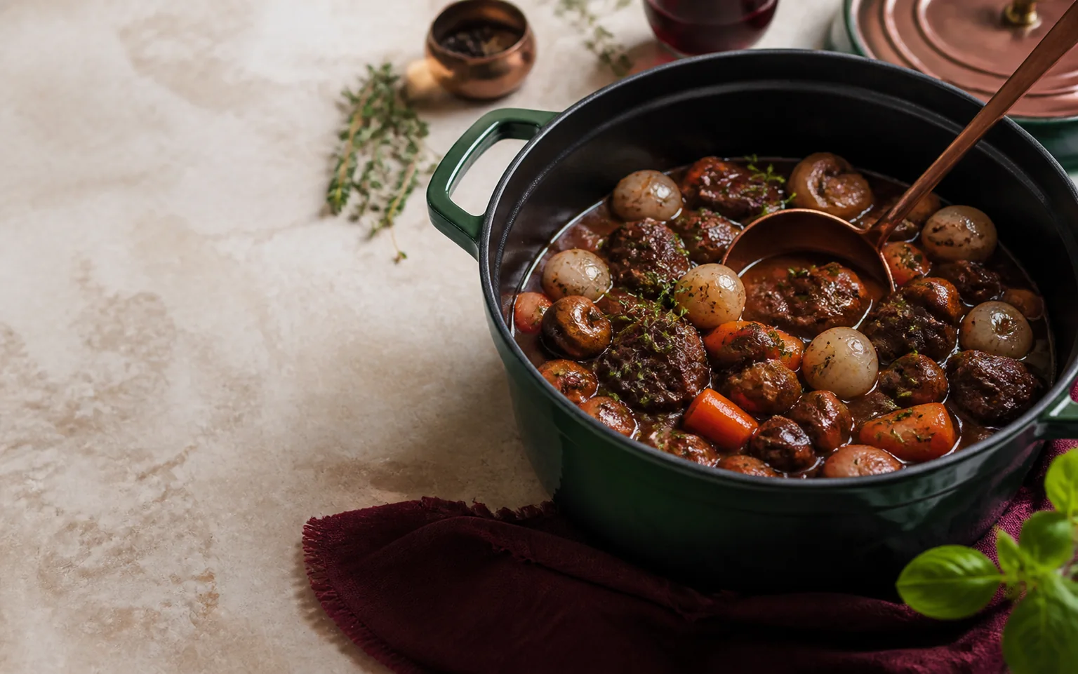 Bœuf bourguignon mijoté avec carottes, champignons et petits oignons dans une cocotte verte